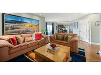 Cozy living room features comfortable couches, wood coffee table and mountain landscape art at 300 W 11Th Ave # 15F, Denver, CO 80204