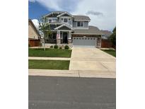 Charming two-story home with stone accents, a well-manicured lawn, and a welcoming front porch at 484 N Jamestown Way, Aurora, CO 80018