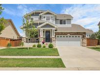 Beautiful two-story home boasts a manicured lawn, stone accents, and an attached two-car garage at 484 N Jamestown Way, Aurora, CO 80018
