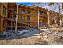 Multi-level condo with wooden balconies, natural landscaping, and a stone walkway leading to the entrance at 820 Columbine Rd # 10, Breckenridge, CO 80424