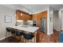 Well-lit kitchen with stainless steel appliances, modern pendant lights and breakfast bar at 4200 W 17Th Ave # 621, Denver, CO 80204