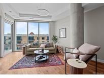 Bright living room featuring hardwood floors, large windows, and modern decor with a view at 4200 W 17Th Ave # 621, Denver, CO 80204