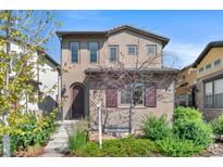 Two-story home featuring a stucco exterior, arched entryway, manicured landscaping, and a concrete step pathway at 15525 W La Salle Ave, Lakewood, CO 80228