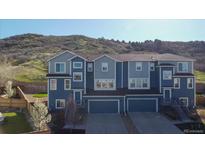 Modern townhouse with a two-car garage and a charming exterior, nestled near a scenic hillside at 1828 Blue Oak Ct, Castle Rock, CO 80104