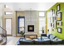 Bright living room features a fireplace, large windows, and blue accent rug at 2432 Champa St, Denver, CO 80205