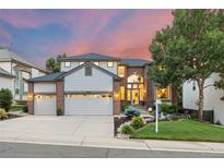 Inviting two-story home featuring a three-car garage, brick accents, and well-manicured landscaping at 18126 E Alamo Dr, Centennial, CO 80015