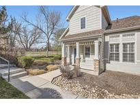 Charming home featuring a covered front porch, stone accents, and manicured landscaping, creating inviting curb appeal at 8300 Fairmount Dr # J105, Denver, CO 80247