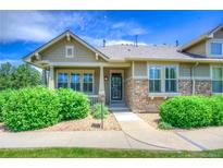 Charming home featuring manicured landscaping, stone accents, and a welcoming front porch at 8594 W Quarto Ave, Littleton, CO 80128