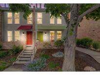 Charming townhome exterior featuring colorful awnings, a brick facade, and a landscaped front yard at dusk at 1150 Inca St # 43, Denver, CO 80204
