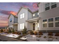 Charming modern townhome with beautiful landscaping and snow-dusted yard at sunset at 8055 Navajo River Loop # B, Littleton, CO 80125