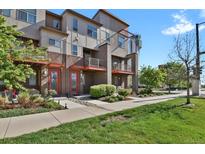 Modern townhome exterior featuring a well-maintained lawn and a neatly landscaped entrance at 8187 Martin Luther King Blvd, Denver, CO 80238