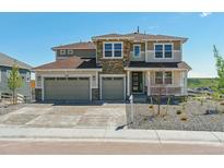 Beautiful two-story home with a three car garage, stone accents, and a welcoming front porch at 4728 Twelve Oaks Way, Castle Rock, CO 80104