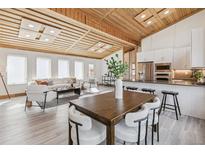 Bright open-concept living room and kitchen with wood plank ceiling and modern design at 2650 W Asbury Ave, Denver, CO 80219
