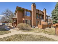 Charming two-story home boasts a warm wood exterior, complemented by mature landscaping and a welcoming walkway at 8040 Holland Ct # C, Arvada, CO 80005