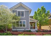 Charming two-story home with gray siding, white trim, a covered porch, and a well-manicured front yard with a picket fence at 2924 Fulton St, Denver, CO 80238