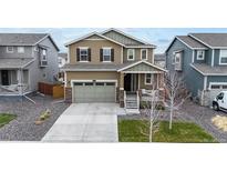 Charming two-story home featuring a well-manicured lawn, attached two car garage, and inviting front porch at 13144 E 109Th Pl, Commerce City, CO 80022