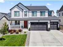 Beautiful two-story home with modern farmhouse style, featuring a red door, and a well-manicured front lawn at 1425 Hart Ln, Elizabeth, CO 80107
