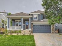 Charming two-story home with well-manicured lawn, covered porch, and attached two car garage at 9865 Centre Cir, Parker, CO 80134