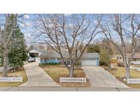 Charming blue ranch-style home with a well-maintained yard and long driveways on a tree-filled lot at 2225 Linda Vista Dr, Lakewood, CO 80215