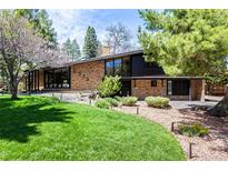 Stunning front exterior of the home featuring a brick facade, large windows, and a well-manicured lawn at 6975 S Chase Ct, Littleton, CO 80128