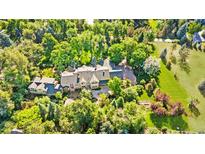 Stunning aerial view of estate home surrounded by lush trees and landscaped grounds at 1700 E Tufts Ave, Cherry Hills Village, CO 80113