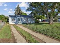Charming single-story home with mature trees, a ramp, and a concrete driveway at 2105 S Irving St, Denver, CO 80219