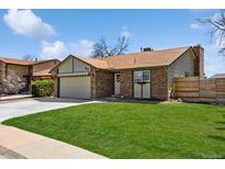 Charming brick home featuring a well-manicured lawn and attached garage in a residential neighborhood at 9532 W Walden Ave, Littleton, CO 80128