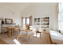 Bright living room featuring vaulted ceilings, built-in shelving, and large windows for natural light at 6512 S Taft Way, Littleton, CO 80127