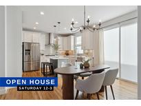 Bright kitchen with stainless steel appliances, island and modern chandelier at 3361 Yukon Ct, Wheat Ridge, CO 80033