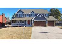 Charming two-story home featuring a covered porch, well-manicured lawn, and a convenient two-car garage at 6526 N Windfield Ave, Parker, CO 80134