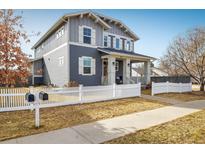 Charming two-story home featuring a welcoming front porch and white picket fence at 722 Hutchinson St, Louisville, CO 80027