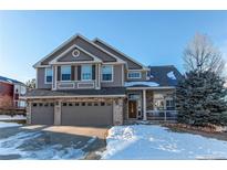 Two-story house with three-car garage, snow-covered front yard, and landscaping at 11555 Pine Hill Way, Parker, CO 80138