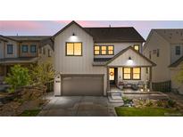 Charming two-story home with landscaped front yard, covered porch, and attached two car garage during sunset at 9140 Moondance Sw Dr, Littleton, CO 80125