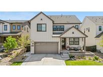 Charming two-story home with landscaped front yard, covered porch, and attached two car garage at 9140 Moondance Dr, Littleton, CO 80125