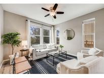 Bright living room features a ceiling fan, large windows, modern furniture, and a striped area rug at 2820 Macon Way, Denver, CO 80238