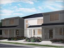 Charming new construction townhomes featuring stone accents and covered front porches with manicured landscaping at 6521 N Malaya St, Aurora, CO 80019