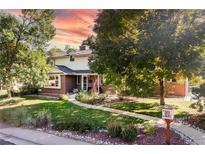 Charming two-story home with brick accents, a manicured lawn, and mature shade trees at 6906 S Sycamore St, Littleton, CO 80120