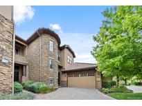Elegant stone townhouse with a two-car garage and beautiful landscaping at 7882 Vallagio Ln, Englewood, CO 80112