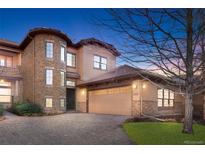 Beautiful two-story home featuring stone accents, a large garage, and a well-manicured lawn at 7882 Vallagio Ln, Englewood, CO 80112