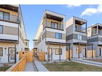 Modern townhome with balconies, stylish color palette, and inviting walkway to the front door at 1727 Lowell Blvd, Denver, CO 80204