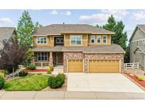 Charming two-story home features a brick and siding exterior, well-manicured lawn, and a convenient two-car garage at 1997 Fox Haven Dr, Castle Rock, CO 80104