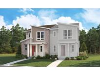 Charming two-story home with a combination of stone, siding and decorative brick, set against a backdrop of lush greenery at 1224 Penner Dr, Erie, CO 80026