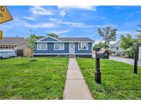 Charming blue home with a well-maintained front yard and inviting walkway at 7810 Larkwood St, Commerce City, CO 80022