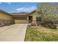 Charming ranch home with a well-maintained lawn, beautiful flowering tree, and two car garage at 19407 E Radcliff Pl, Aurora, CO 80015