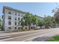 An exterior side view of a large apartment building showcasing its classic architectural design and surrounding streetscape at 215 E 11Th Ave # B9, Denver, CO 80203