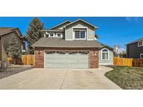 Charming home featuring a two-car garage with a brick facade and neutral trim at 10707 W Cooper Dr, Littleton, CO 80127