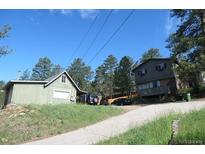 Exterior view of a house with a paved driveway and surrounding trees on a sunny day at 28127 Knowles Rd # Ab&C, Evergreen, CO 80439