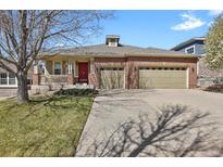 Charming brick home featuring a three-car garage, front porch, and well-maintained lawn at 2775 S Jebel Way, Aurora, CO 80013