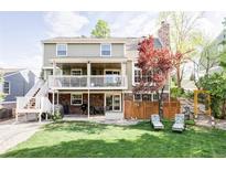 Expansive backyard featuring a two-story deck, a grill, and manicured lawn for outdoor enjoyment at 9867 W Berry Dr, Littleton, CO 80123