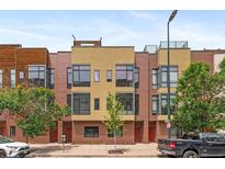 Contemporary townhome featuring a brick facade, large windows, and a rooftop deck at 2325 Walnut St # 4, Denver, CO 80205
